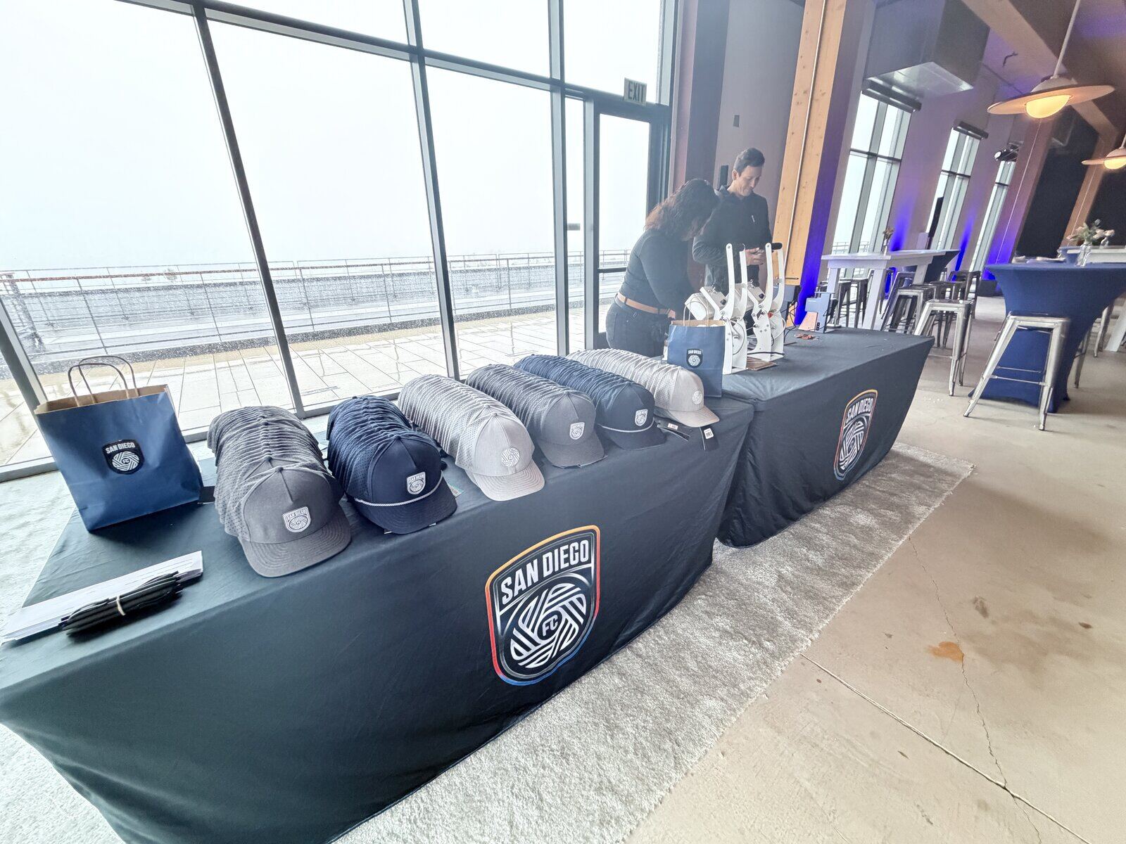 Guests at a corporate hat bar activation choosing caps and watching decoration