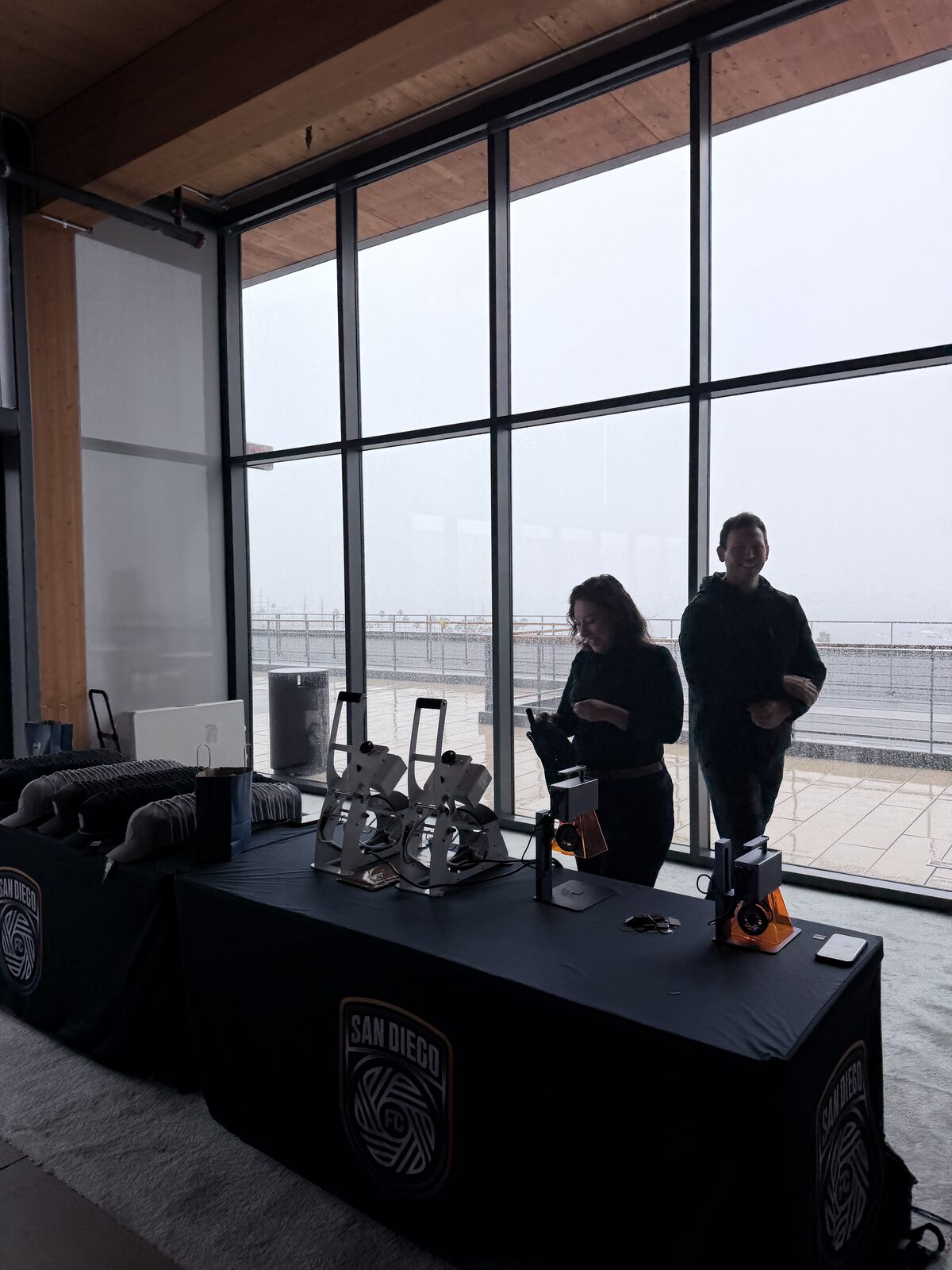 Hat press station with a branded window graphic at a company event