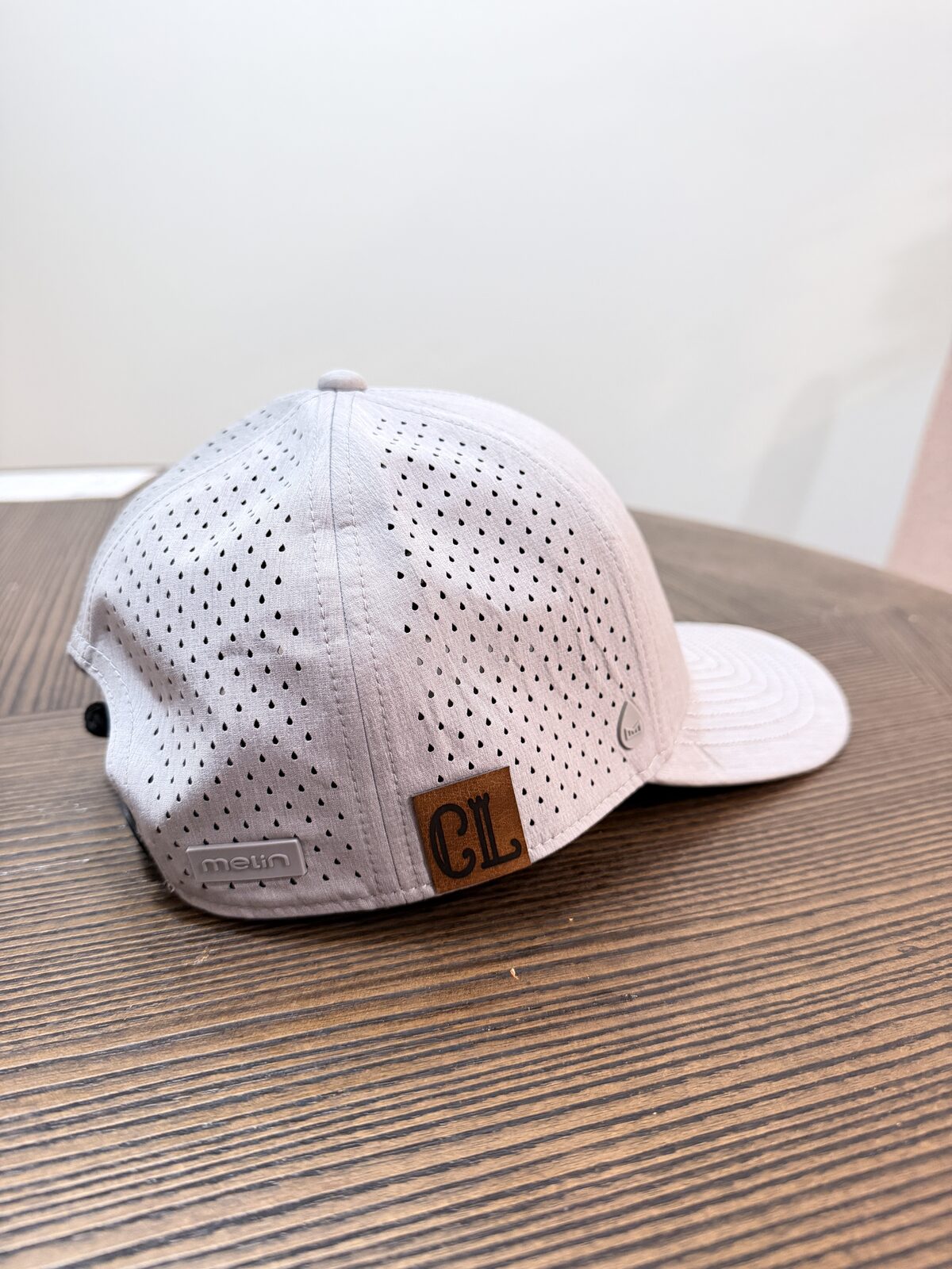 Custom debossed leather patch applied to a trucker cap at a corporate hat bar